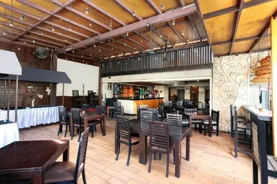 a dining room with wooden tables and chairs at The Sun Hotel & Spa Legian in Legian