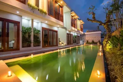a swimming pool in front of a house at Legian Bisma Suite in Seminyak