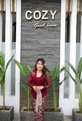 a young girl standing in front of a guest house at Cozy Umalas Guesthouse in Kerobokan