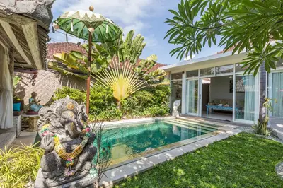 a swimming pool with an elephant statue next to a house at Villa Maloa in Denpasar
