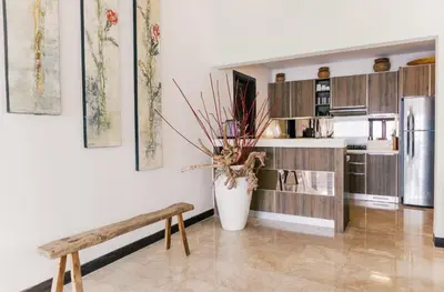 a kitchen with a vase and a bench in a room at Villa Sunset by Premier Hospitality Asia in Nusa Dua
