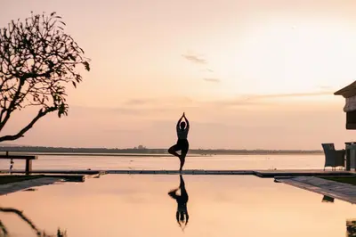 a woman doing a yoga pose in a pool of water at Villa Sunset by Premier Hospitality Asia in Nusa Dua