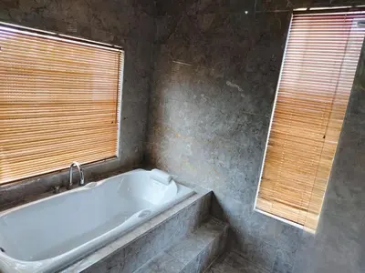 a bathroom with a bath tub and a window at The Oasis Retreat Seminyak in Seminyak
