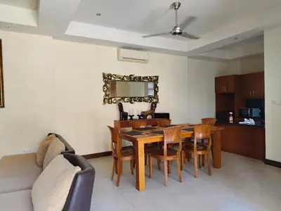 a living room with a table and chairs and a couch at The Oasis Retreat Seminyak in Seminyak