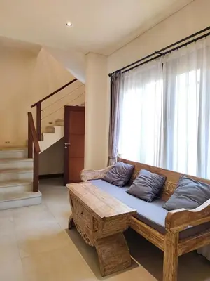 a wooden couch in a room with a window at The Oasis Retreat Seminyak in Seminyak