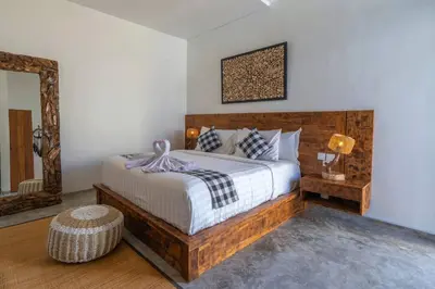 a bedroom with a large bed and a mirror at Miracle villa Canggu in Canggu
