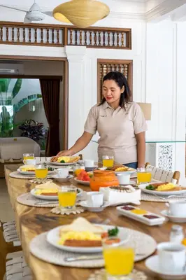 a woman standing in front of a table full of food at Villa Lisabella by Villa Finder in Seminyak