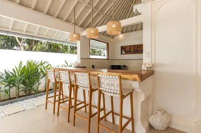 a kitchen with a wooden bar with stools at Villa Lisabella by Villa Finder in Seminyak