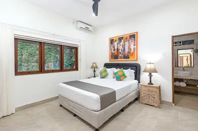 a white bedroom with a large bed and a window at Villa Yati in Seminyak