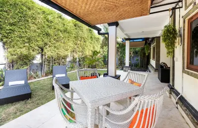 a patio with a table and chairs on a porch at Villa Yati in Seminyak