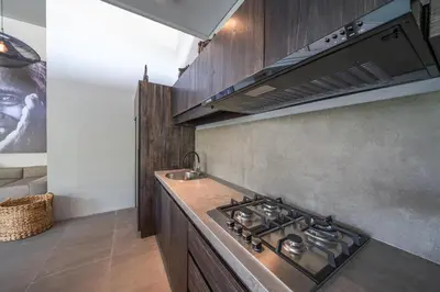 a kitchen with a stove and a sink at Villa Wiraja 1 - Modern 4 bdr villa in Berawa in Canggu