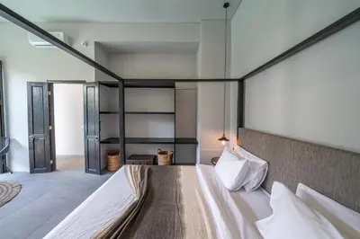 a bedroom with a large bed with white sheets at Villa Wiraja 2 - Classy 4 bdr villa in the heart for Canggu in Canggu
