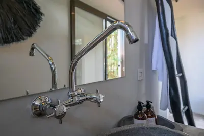 a bathroom sink with a faucet and a mirror at Villa Wiraja 2 - Classy 4 bdr villa in the heart for Canggu in Canggu