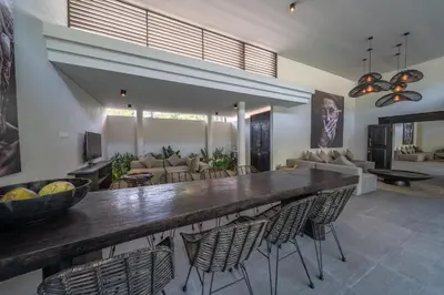 a living room with a large table and chairs at Villa Wiraja 2 - Classy 4 bdr villa in the heart for Canggu in Canggu