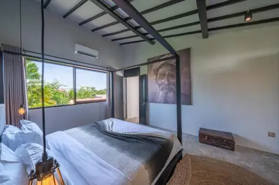 a bedroom with a bed and a large window at Villa Wiraja 2 - Classy 4 bdr villa in the heart for Canggu in Canggu