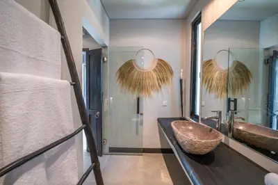 a bathroom with a sink and a large mirror at Villa Wiraja 2 - Classy 4 bdr villa in the heart for Canggu in Canggu