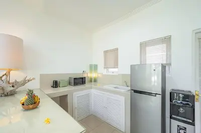 a kitchen with a refrigerator and a sink at Villa Margaretta in Seminyak