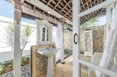 a bathroom with a sink next to a door at Sol Lila Bali in Canggu