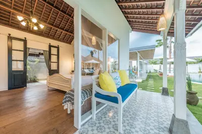 a villa bedroom with a bed and a patio at Sol Lila Bali in Canggu