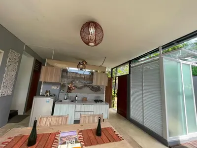 a kitchen and dining room with a table and a counter at Modern Balinese Villa with Scenic View in Nusa Dua