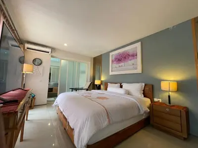 a bedroom with a large bed and a desk at Modern Balinese Villa with Scenic View in Nusa Dua