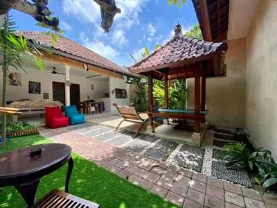 an outdoor patio with a table and a bench at Timaya Villa BEST LOCATION in Legian