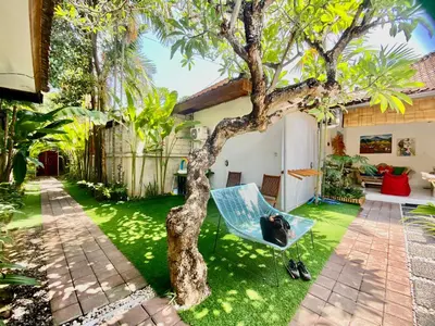 a blue chair sitting next to a tree in a yard at Timaya Villa BEST LOCATION in Legian
