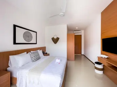 a bedroom with a bed and a flat screen tv at Puspa Ayu Villas & Apartments in Kuta