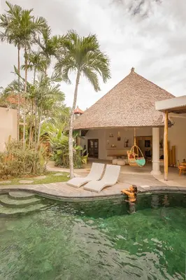 a villa with a swimming pool and a house at Lamoon Villas Berawa in Canggu