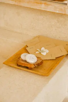 a wooden tray with a pastry with a flower on it at Lamoon Villas Berawa in Canggu