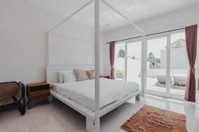 a bedroom with a white canopy bed and a window at Cozy 2BR Private Pool Villa, Oberoi, Central Seminyak, Bali in Seminyak