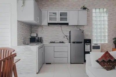 a kitchen with white cabinets and a refrigerator at Cozy 2BR Private Pool Villa, Oberoi, Central Seminyak, Bali in Seminyak