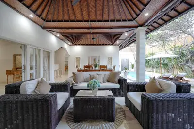 an outdoor living room with wicker furniture and a ceiling at Villa Noni Seminyak in Seminyak