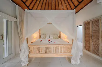 a bedroom with a bed with a canopy at Villa Noni Seminyak in Seminyak