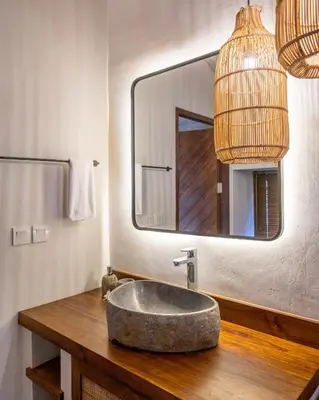 a bathroom with a stone sink and a mirror at Villa Annabelle Canggu in Kerobokan