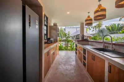 a kitchen with wooden cabinets and a sink at Villa Annabelle Canggu in Kerobokan