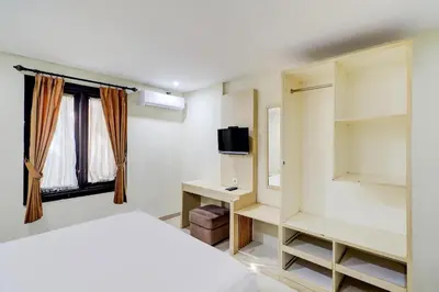 a bedroom with a bed and a tv in it at Collection O Near Bajra Sandi Monumen Formerly Grand Pondok Puri Ayu in Denpasar