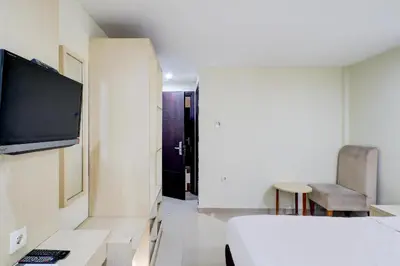 a room with a bed and a tv on a wall at Collection O Near Bajra Sandi Monumen Formerly Grand Pondok Puri Ayu in Denpasar