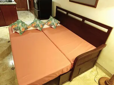 two beds in a room with orange sheets and pillows at Jayakarta Residence - Sandy Sunset Suite 1BR - 6432 in Seminyak