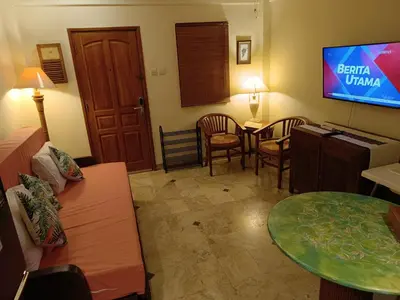 a living room with a couch and a tv at Jayakarta Residence - Sandy Sunset Suite 1BR - 6432 in Seminyak