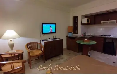 a living room with a tv and a kitchen at Jayakarta Residence - Sandy Sunset Suite 1BR - 6432 in Seminyak