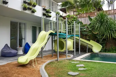 a playground with a slide next to a pool at Villa Iluka by SooBali in Seminyak