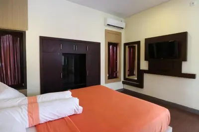 a hotel room with a bed and a tv at Kondra Premiere Guest House Kuta in Kuta