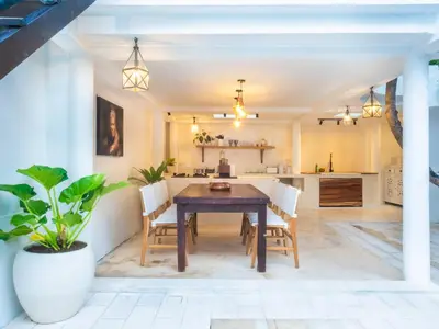 a kitchen and dining room with a wooden table and chairs at Ocean Star 1 in Seminyak