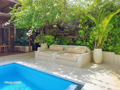 a couch sitting next to a swimming pool at Ocean Star Villa Four Bedrooms Seminyak in Seminyak