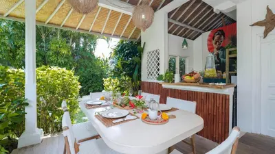 a dining room with a white table and chairs at Ocean Star 2 in Seminyak