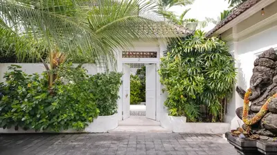 an entrance to a white house with plants at Ocean Star 2 in Seminyak