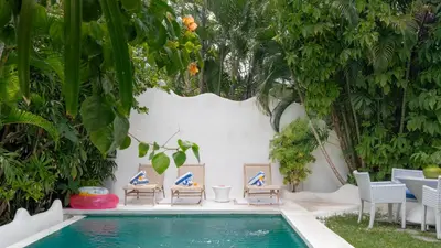 a swimming pool with chairs and a table and a pool at Ocean Star 2 in Seminyak