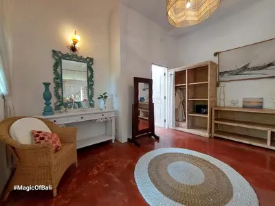 a living room with a chair and a mirror at Ocean Star 3 in Seminyak