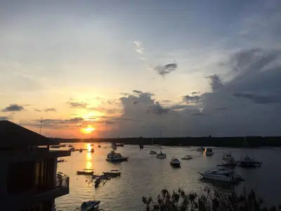 a group of boats in the water at sunset at PIMA Homestay in Pesanggaran